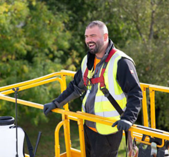 man in a high-lift platform wearing a hi-vis
