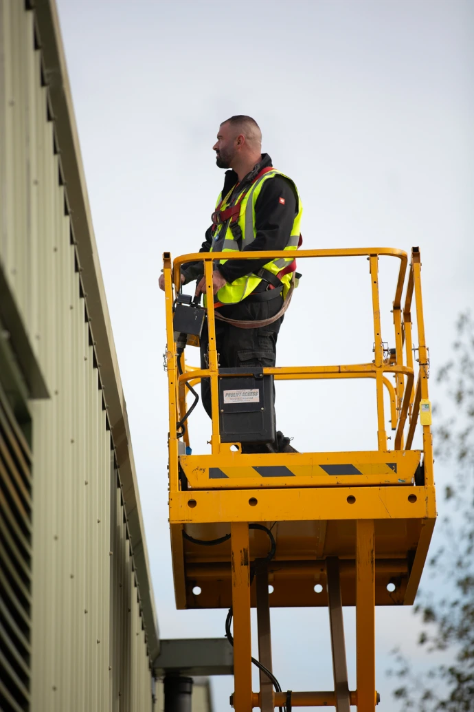 a man in a hi-vis on a scissor lift